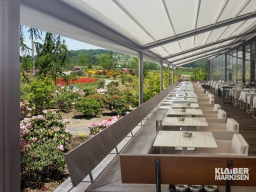 Bestuhlte Terrasse an einem Restaurant mit Pergolamarkise